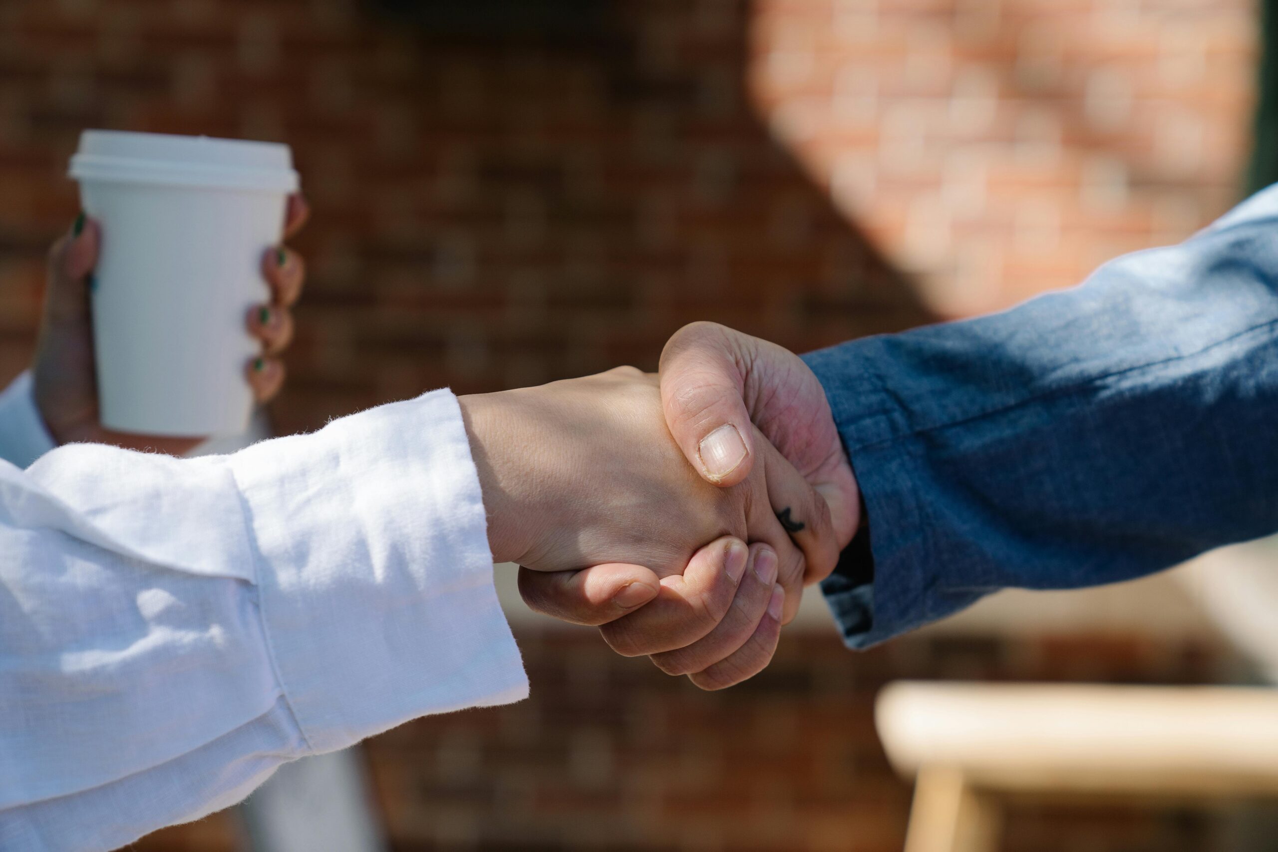Close-up of a handshake between two adults, symbolizing agreement or partnership.